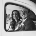 Newlyweds in back of London taxi waving through window