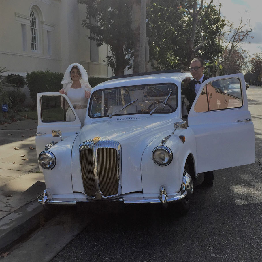 Newlyweds getting into London taxi cab on either side