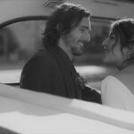 Newlyweds in back of London taxi carriage looking at each other black and white