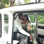 Bride and groom stealing a kiss in the back of white '92 London Taxi