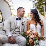 Happy bride and groom in back of Taxi car with convertible top open