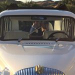 Wedding couple kissing in the back seat of a London Taxi cab.
